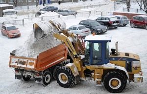 Погрузка снежной массы в самосвал трактором-погрузчиком JCB